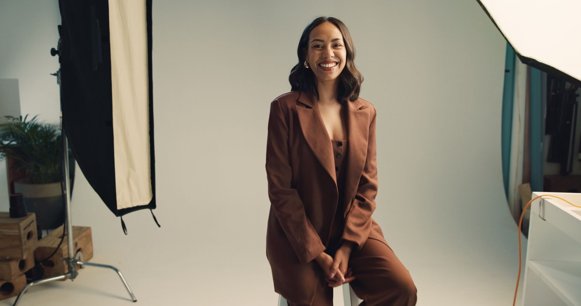 Photography, studio and model with portrait backstage for fashion photoshoot, magazine catalog and creative career. Behind the scenes, woman and happy on set for campaign project and article cover