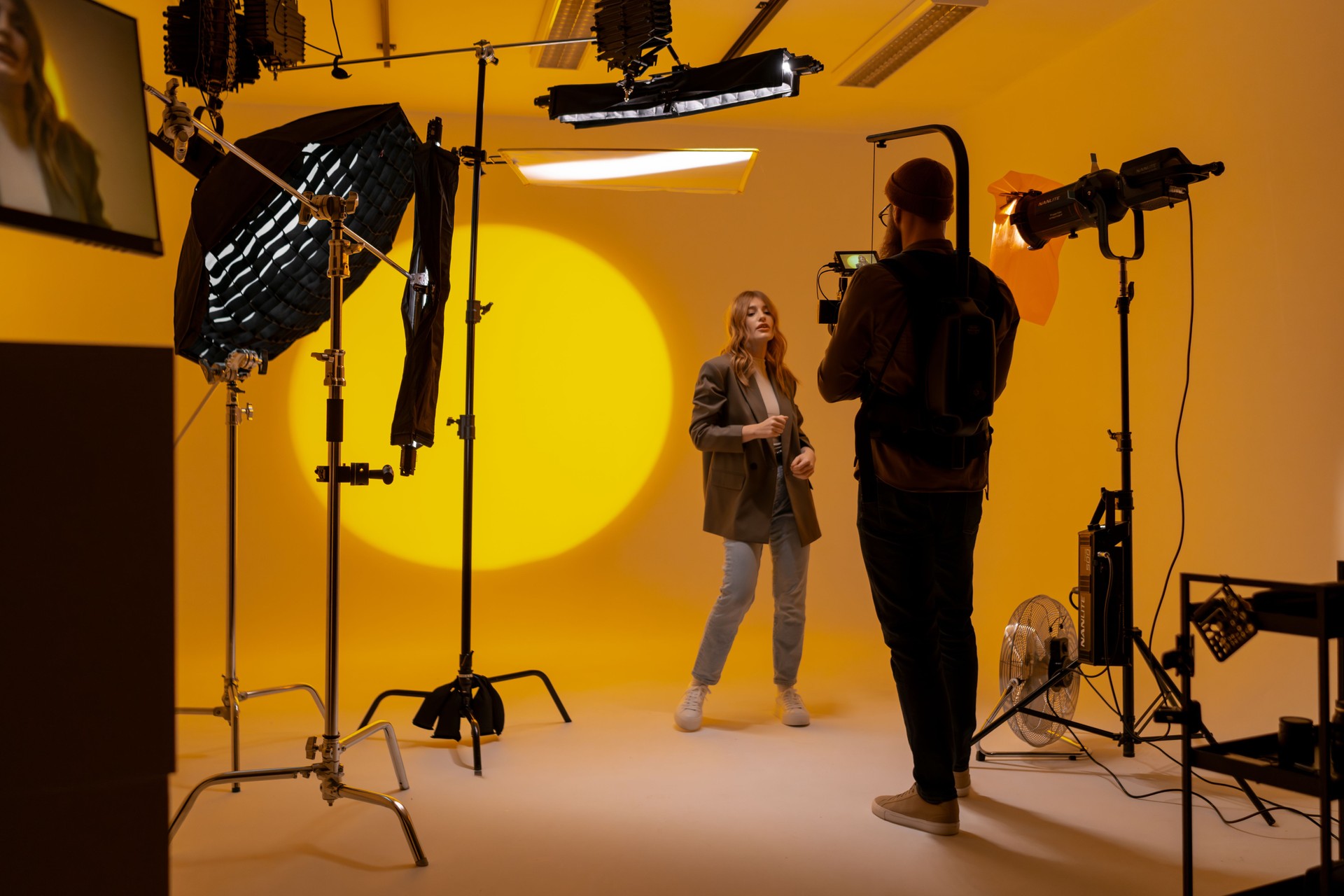 Videographer capturing footage in a yellow room with a camera